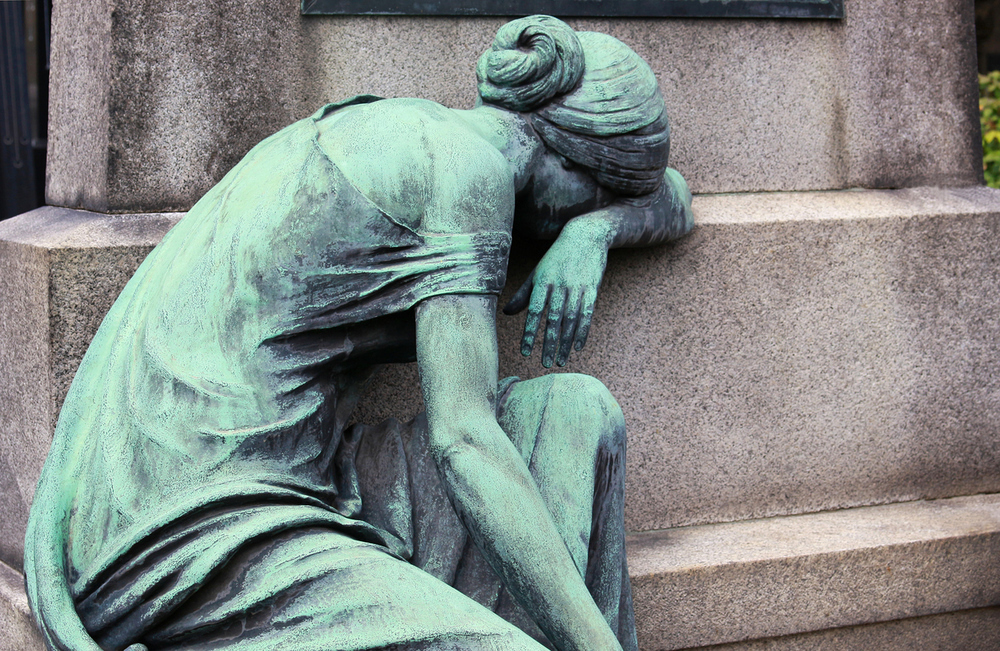 Statue einer trauernden Frau am Friedhof